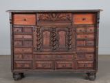 une vieille commode en bois avec de nombreux tiroirs, dont certains montés sur roulettes