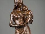 a bronze statue of a woman holding a child