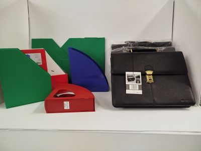 une mallette noire posée sur une étagère blanche, à côté d'une boîte rouge et verte