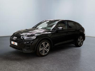 un SUV Audi noir garé dans une pièce aux murs blancs