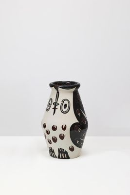 un vase noir et blanc posé sur une table blanche