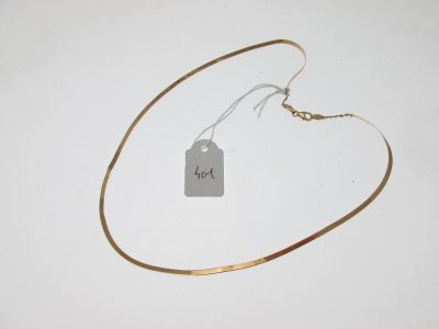 un collier auquel est attachée une étiquette sur une surface blanche