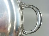 a silver plate with a handle on it on a table