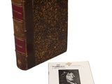 un vieux livre posé sur une table à côté d'un livre