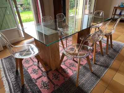 une table en verre avec des chaises et un tapis au sol