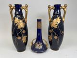 two blue vases with gold leaf designs and a cork stopper