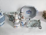 many pieces of pottery sitting on a white table