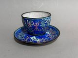 a blue cup and saucer on a white table