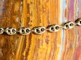 a close up of a gold chain on a rock