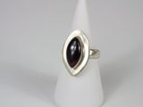 a close up of a silver ring with a red stone in it