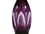un vase violet posé sur une surface blanche