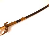 une petite épée en bois avec un manche noir sur un fond blanc