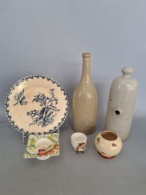 trois vases, une assiette et un vase posés sur une table