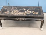 une table basse noire ornée d'un motif floral