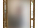 miroir avec un cadre doré et un motif décoratif