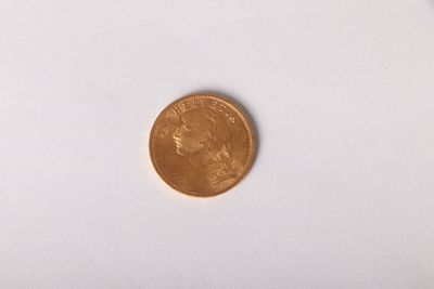 a gold coin sitting on a white surface with a white background