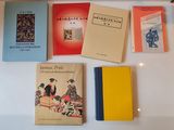 several books are lined up on a white table