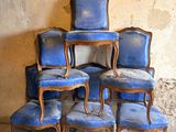 six chaises bleues empilées les unes sur les autres dans une pièce
