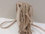 the small sued fringe bag is on a white surface