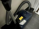 un aspirateur posé sur le sol à côté d'une chaise