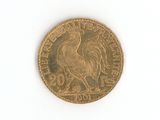 une pièce d'or ornée d'un oiseau sur une surface blanche