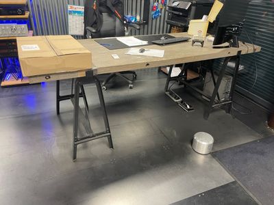 une photo d'un bureau dans un entrepôt, sur lequel se trouvent de nombreux cartons