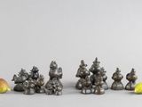 quatre petites figurines métalliques représentant des animaux et une poire posées sur une table
