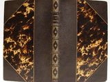 an old book with a brown cover and gold trim