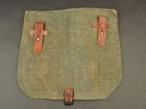 an old canvas bag with leather handles on a table