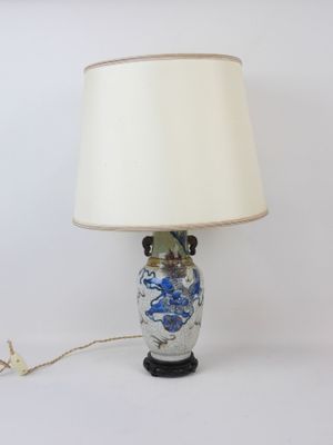 an image of a table lamp with a blue and white vase on it