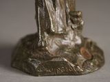 a bronze statue of a man and a dog on a rock