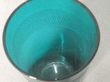a blue glass with a silver rim on a table