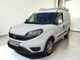 La camionnette blanche est garée dans une grande pièce aux murs blancs.