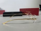 cartier eyeglasses are displayed on a table next to a pair of glasses