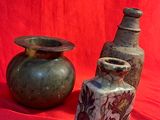 two vases sitting next to each other on a red cloth