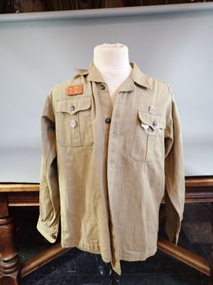 an image of a shirt on a mannequin stand in front of a wall