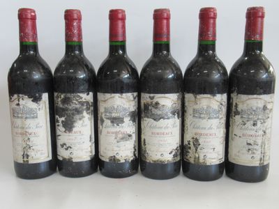 six bouteilles de vin sont alignées sur une table