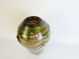 a vase with moss growing on it on a white surface