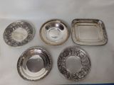 six silver plated dishes on a white tablecloth with a blue background