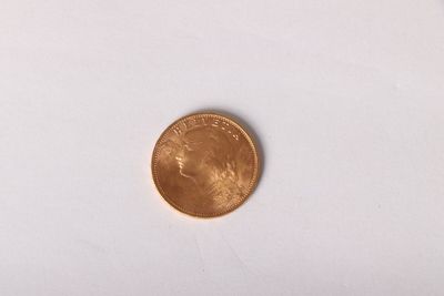 a close up of a penny sitting on a white surface