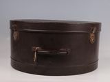 une valise marron posée sur une table blanche