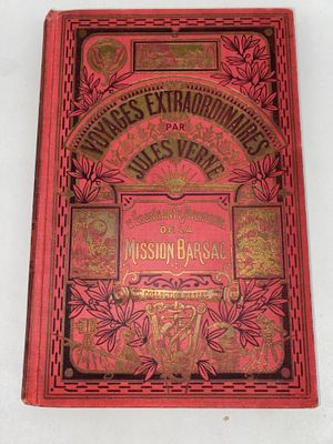an old red book sitting on top of a white table
