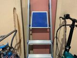 un vélo et une échelle près d'un mur rose