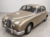 une photo d'une voiture de couleur beige garée dans une pièce