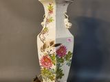 un vase blanc orné d'un oiseau et de fleurs