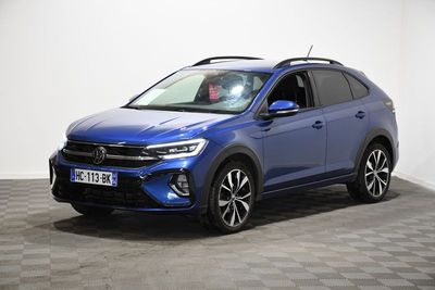 un SUV Volkswagen bleu garé sur un sol à damier