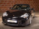 a black sports car parked in front of a brick wall