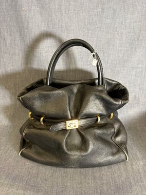 sac à main en cuir noir avec des finitions dorées sur la poignée