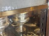 a glass display case with a bunch of silver candles
