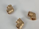 three brass pipe fittings on a white surface